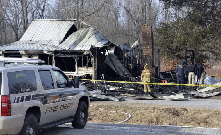 Members of the Kentucky State Fire Marshall's office look over the remains of a house fire in Muhlenberg County, Ky., Thursday Jan. 30, 2014.