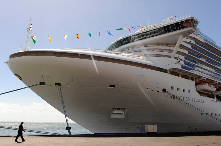 A man passes the Caribbean Princess cruise ship being used as official accommodation for attendees of the CHOGM (Commonwealth Heads of Government Meet...