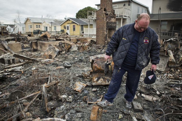 Kieran Burke surveys the burned-out remains of his Breezy Point, N.Y., home on Wednesday, Oct. 31, 2012. Breezy Point residents returned to their deva...