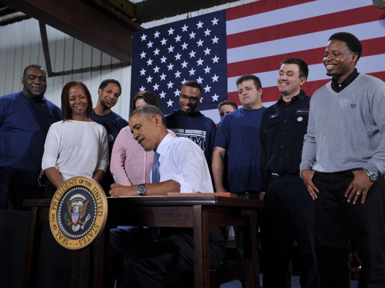President Barack Obama signs a memorandum on job training after speaking at the General Electric Waukesha Gas Engines facility on January 30, 2014 in Waukesha, Wisconsin.