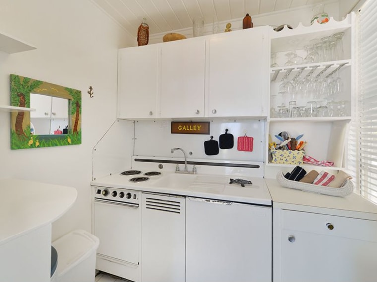 The houseboat includes a galley kitchen on the first deck.