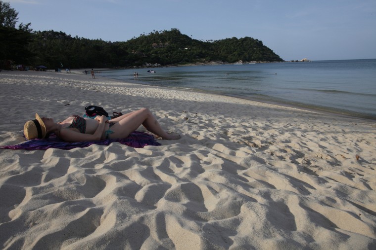 A woman sunbathes along the beach at the Anantara Rasananda resort  June 18, 2012 on the island of Koh Phangan 