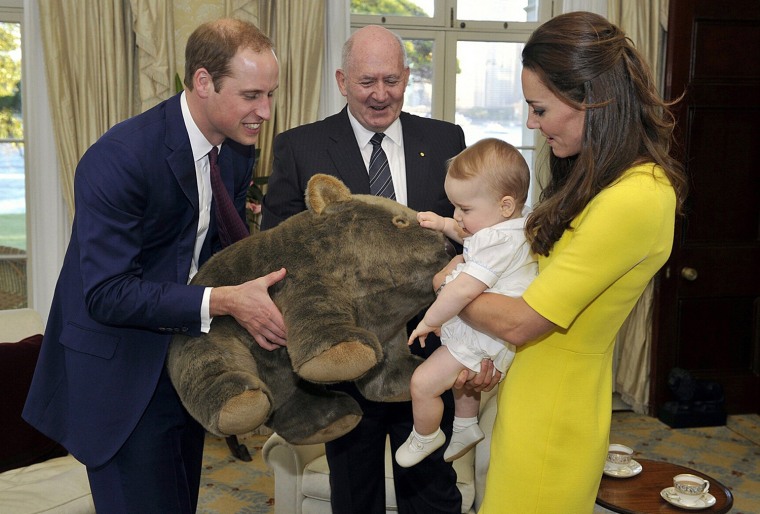 Catherine, the Duchess of Cambridge, holds her son Prince George as his father, Britain's Prince William (L), holds a toy wombat that was given as a p...