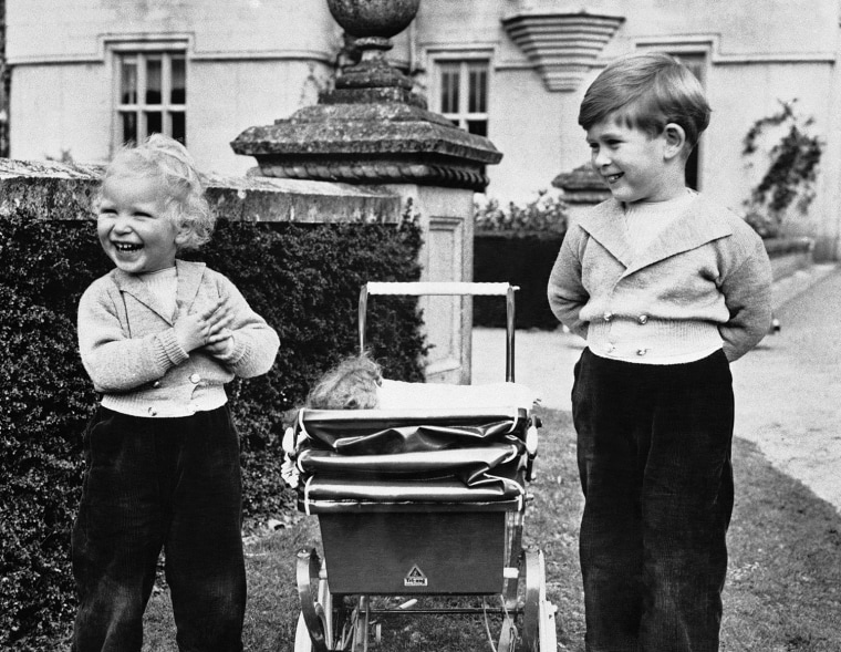 They have a case of the giggles! Prince Charles and his sister, Princess Anne, playing on grounds of Balmoral Castle, Scotland in 1952. They stand on ...