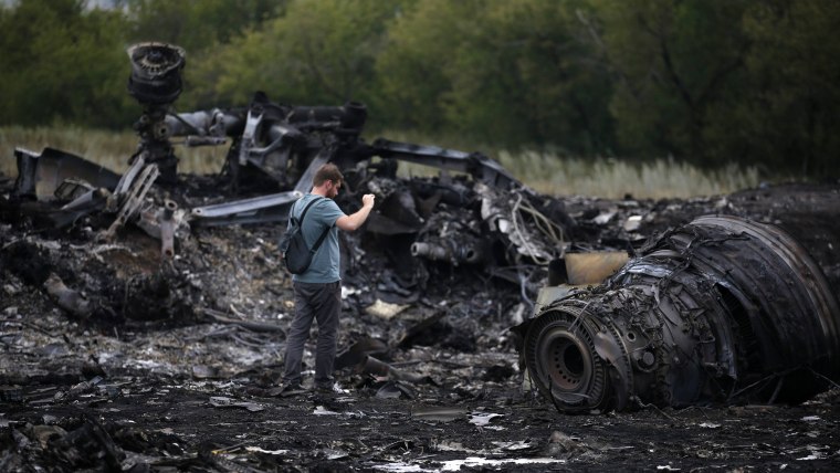A journalist takes photographs at the site of Thursday's Malaysia Airlines Boeing 777 plane crash near the settlement of Grabovo, in the Donetsk regio...