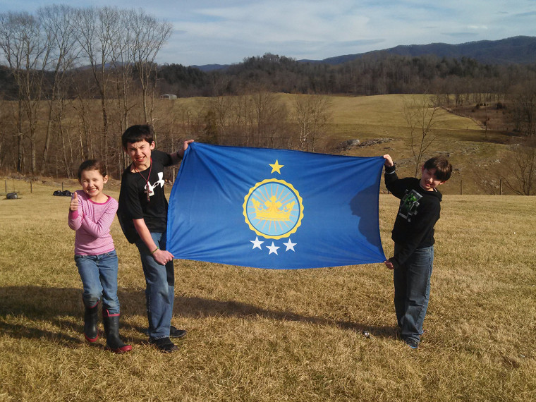 Emily, Justin and Caleb Heaton show off their family flag.