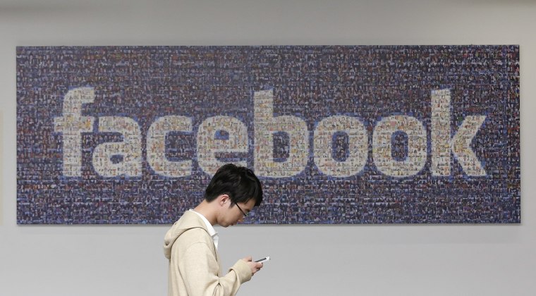 In this June 11, 2014 photo, a man walks past a Facebook sign in an office on the Facebook campus in Menlo Park, Calif. The Proceedings of the Nationa...