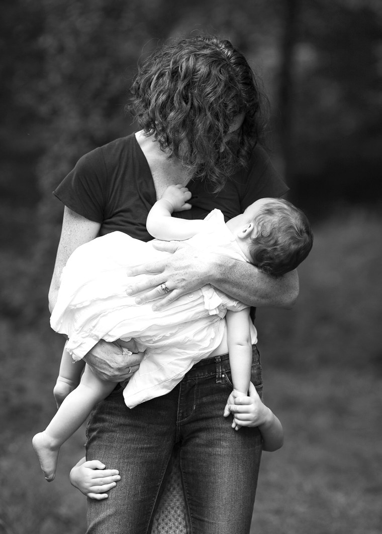 Erica gets a hug from her older child as she nurses the younger one.