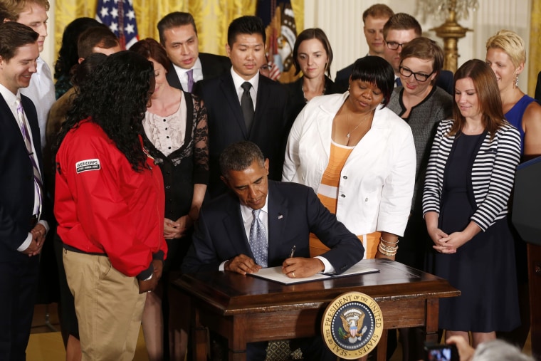 U.S. President Barack Obama signs a presidential memorandum on reducing the burden of student loan debt in the East Room of the White House on June 9, 2014.