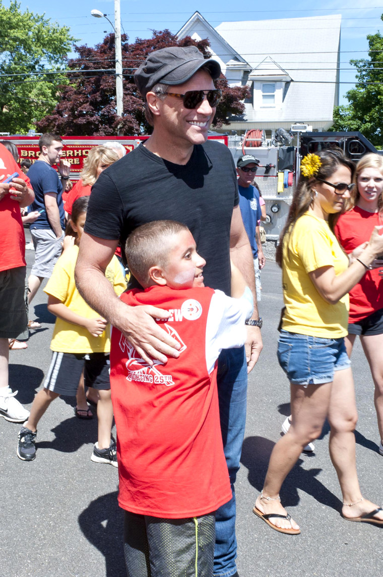 Mario Carpino gives his new friend, Jon Bon Jovi, a big hug while walking around Carpino's cancer fundraiser.
