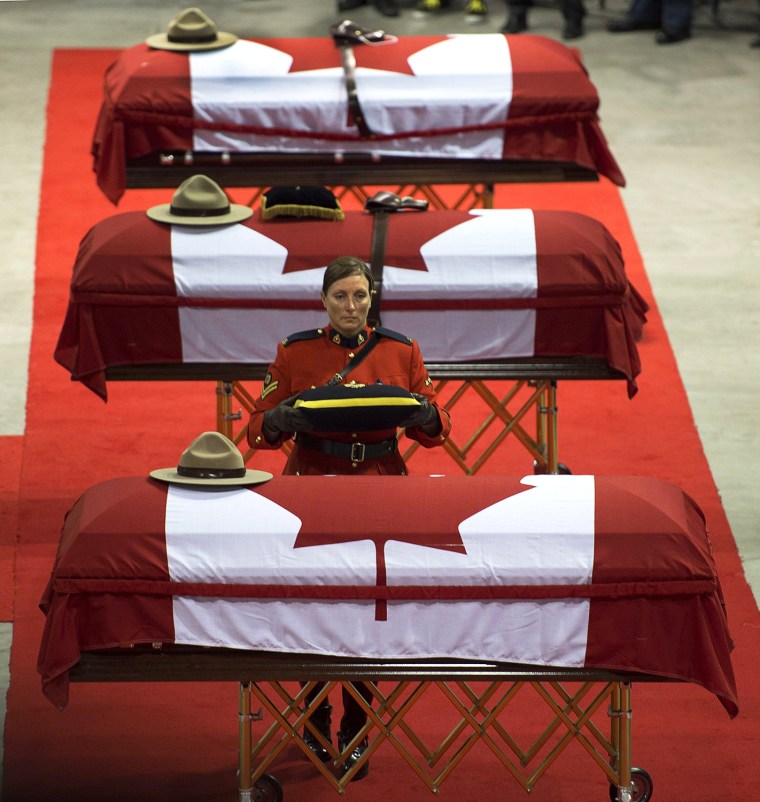 The caskets of the three RCMP officers who were killed in the line of duty are draped witth the Canadian flag at the regimental funeral at the Moncton...