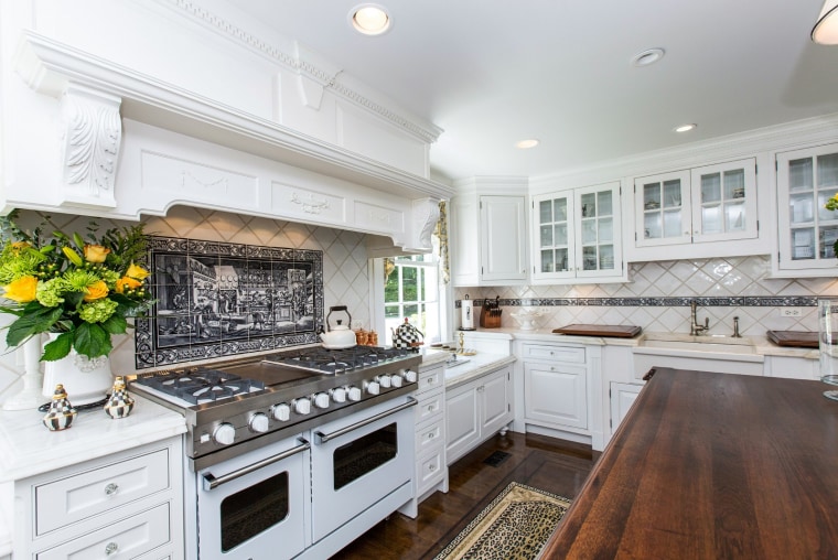 The home features an all-white kitchen, eight bedrooms and eight fireplaces.