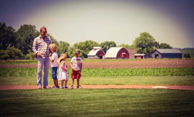 Kevin Costner and his three children walk the bases.