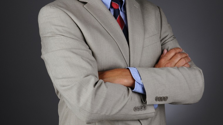 Closeup of a businessman standing with his arms crossed.