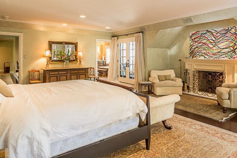 The master bedroom includes a balcony overlooking gardens and the pool.