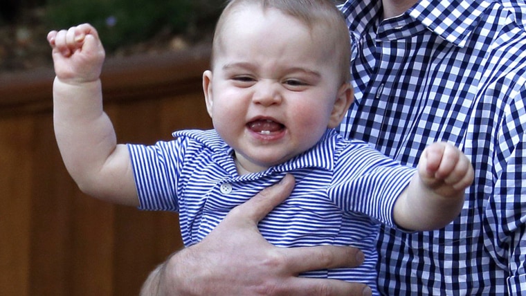 Britain's Prince George reacts in his father Prince William's arms after looking at an Australian animal called a Bilby, which has been named after th...