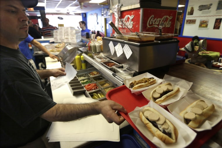 An employee at Hot Doug's in Chicago prepares an order May 7, 2014, at the gourmet hot dog diner.