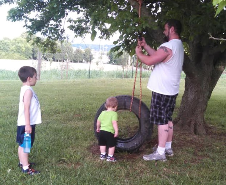 Danny Rogers building a tire swing for sons Timothy and William.