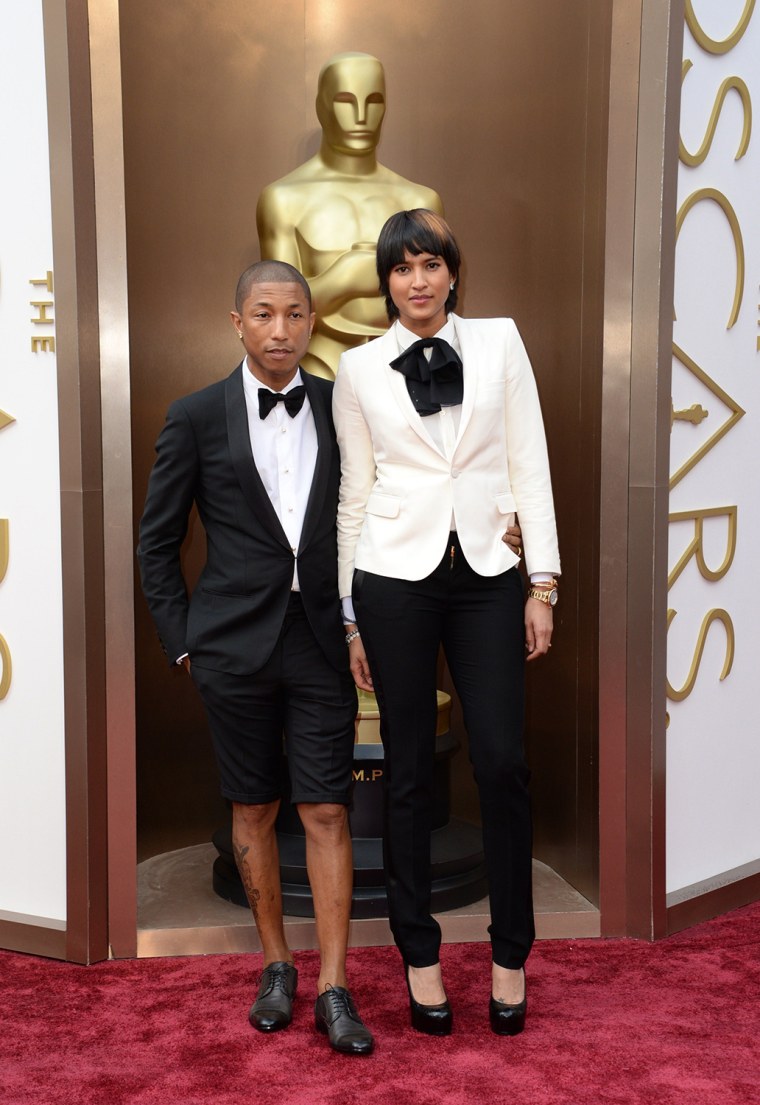 Pharrell Williams (L) and Helen Lasichanh arrive on the red carpet for the 86th Academy Awards on March 2nd, 2014 in Hollywood, California. AFP PHOTO ...