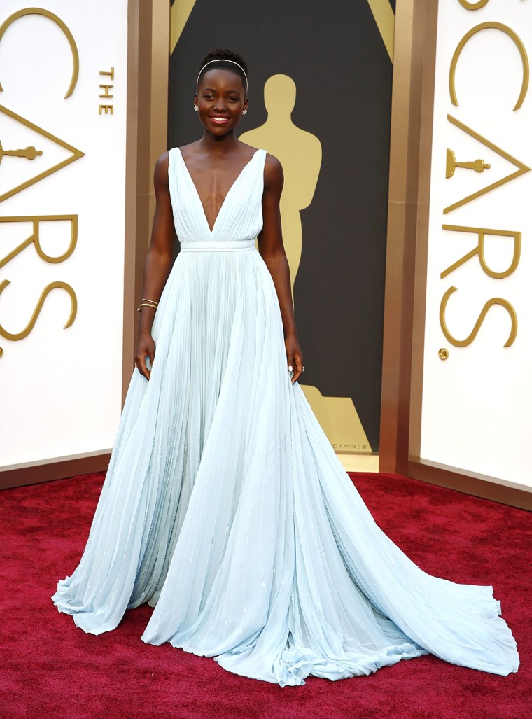 Lupita Nyong'o, best supporting actress nominee for her role in \"12 Years a Slave\", wearing a Fred Leighton headband and a Prada gown prepares to walk...