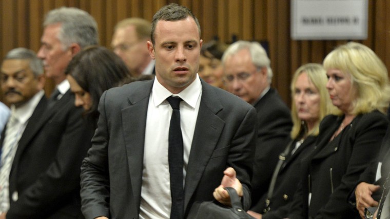 South African Paralympian star Oscar Pistorius (C), accused of murdering his girlfriend Reeva Steenkamp, attends the opening day of his trial, at the ...