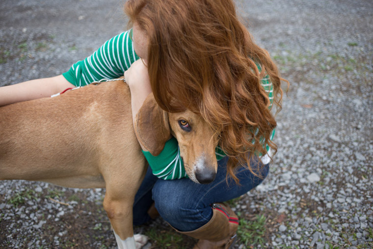 Chara Lemley hugs her Coonhound/Foxhound mix Lipton. She also has another rescue named Luna.