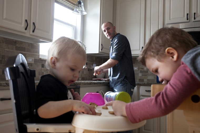 David Juip peels oranges for his two sons Ari, 1, and Jonah, 3, at their home in Wauconda, Ill. Juip has been a stay-at-home dad for two yea...