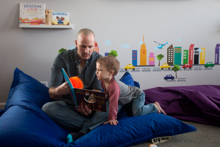 David Juip reads to his son Jonah, 3, at their home March 5, in Wauconda, Ill. Juip has been a stay-at-home dad for two years.