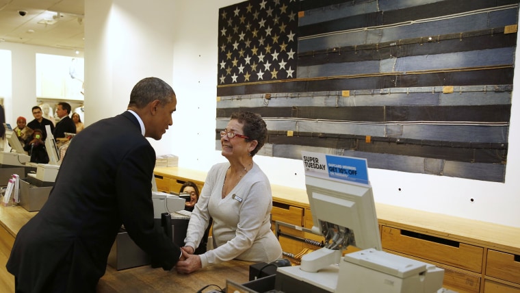 U.S. President Barack Obama shakes hands with cashier Sonia Del Gatto while he looks for gifts for his family after stopping off at the GAP in New Yor...