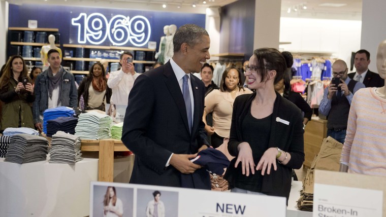 US President Barack Obama shops for clothing for his family alongside store employee Susan Panariello (R) during a visit to a Gap clothing store in Ne...