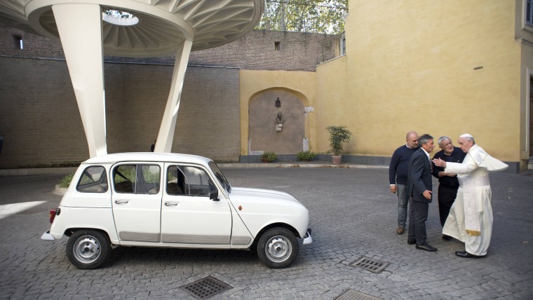 Pope Francis (R) is presented with a Renault 4 car during a private audience with Don Renzo Zocca at the Vatican in this picture taken September 7, 20...