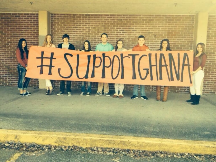 Student leadership posing in front of a banner to raise money for their sister school in Ghana, West Africa.