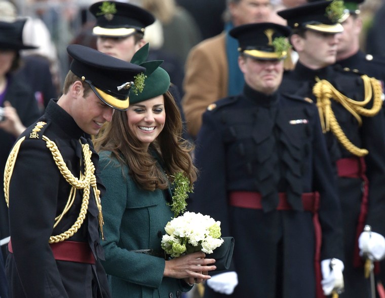 Britain's Catherine, Duchess of Cambridge (2nd L) and her husband Prince William (L) wear sprigs of shamrock during a visit to the 1st Battalion Irish...
