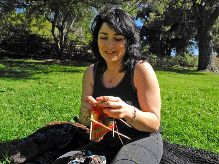 Knitter C.J. Arabia, who took up the craft after her mother's death, is shown working on a new project.