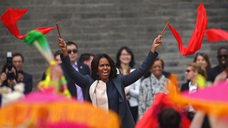 U.S. first lady Michelle Obama (C) dances with folk performers as she visits the City Wall, in Xi'an, Shaanxi province, March 24, 2014. REUTERS/Petar ...