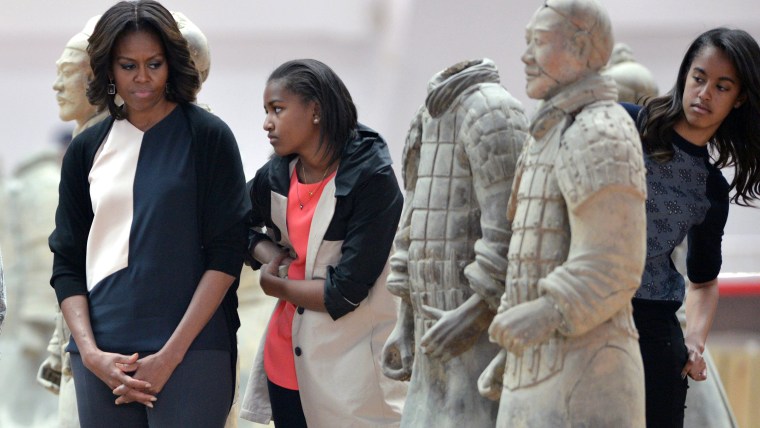 US First Lady Michelle Obama (L) and daughters Sasha (C) and Malia (R) look at the Terracotta Warriors in China's central Shaanxi province of Xian on ...