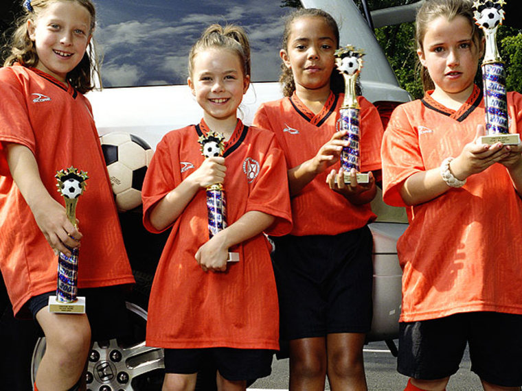 Girls With Trophies -- Parents Can Harm Kids With Too Much Praise