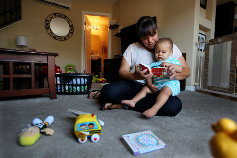 Image: Marisa Mauer,34, reads a book with her 13-month-old son Nathaniel at their home in San Diego, Calif.
