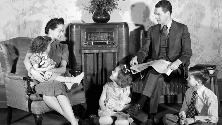 1940s FAMILY MAN FATHER WOMAN MOTHER BOY SON TWO GIRLS DAUGHTERS SITTING TOGETHER LISTENING TO RADIO. H. ARMSTRONG ROBERTS/CLASSICSTOCK/Everett Collec...