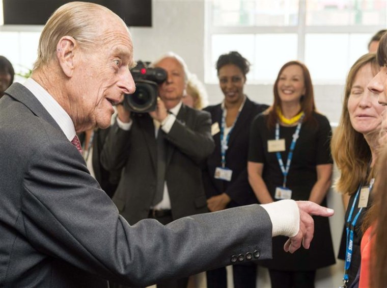 Britain's Prince Philip, left, meets members of staff during a visit to the Margaret Pyke Centre in London on Wednesday, one day after undergoing a procedure on his hand.