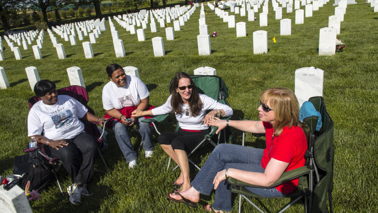 Paula Davis, Xiomara Mena Anderson, Beth Belle, and Gina Barnhurst talk and catch up by their sons graves at Arlington National Cemetery in Arlington,...
