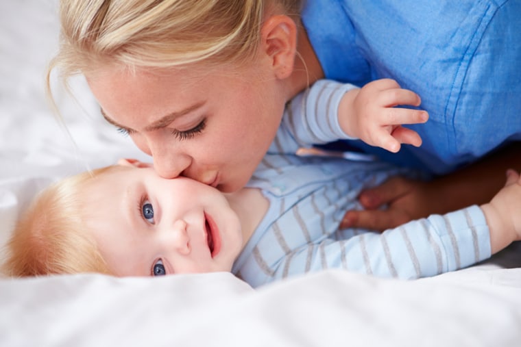 Mother Kissing Baby Son As They Lie In Bed Together; Shutterstock ID 177222668; PO: today-moms-sg-welcome; Job: 141103; Client: today.com