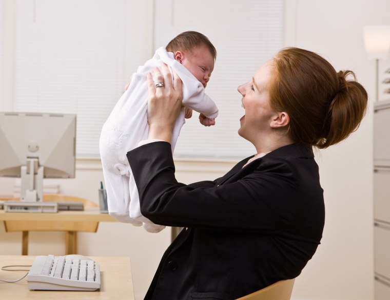 Businesswoman holding baby at desk; Shutterstock ID 48701269; PO: today-moms-sg-welcome; Job: 141103; Client: today.com