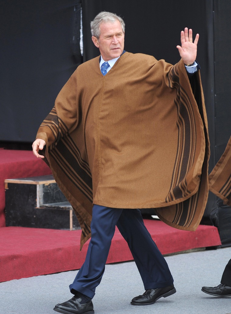 US President George W. Bush, wearing a poncho, walks to pose in the official photograph on November 23, 2008 during the APEC 2008 Summit at the Minist...