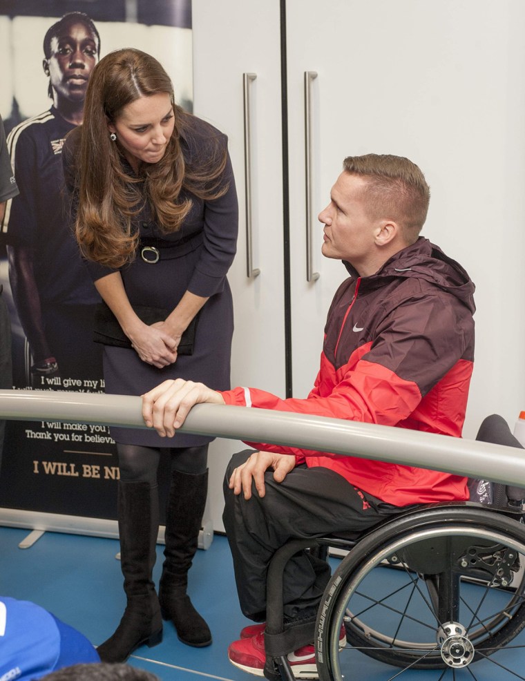 Britain's Catherine, Duchess of Cambridge (L) speaks with wheelchair athlete David Weir during her visit to a SportsAid workshop at the GlaxoSmithKlin...