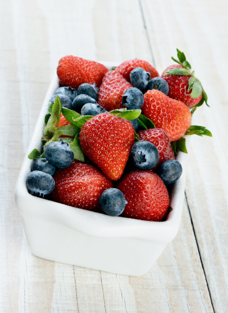 A bowl full of fresh blueberries and strawberries