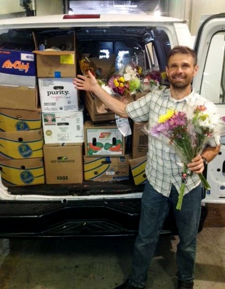Steve Badt stands in front of a van full of food donations.