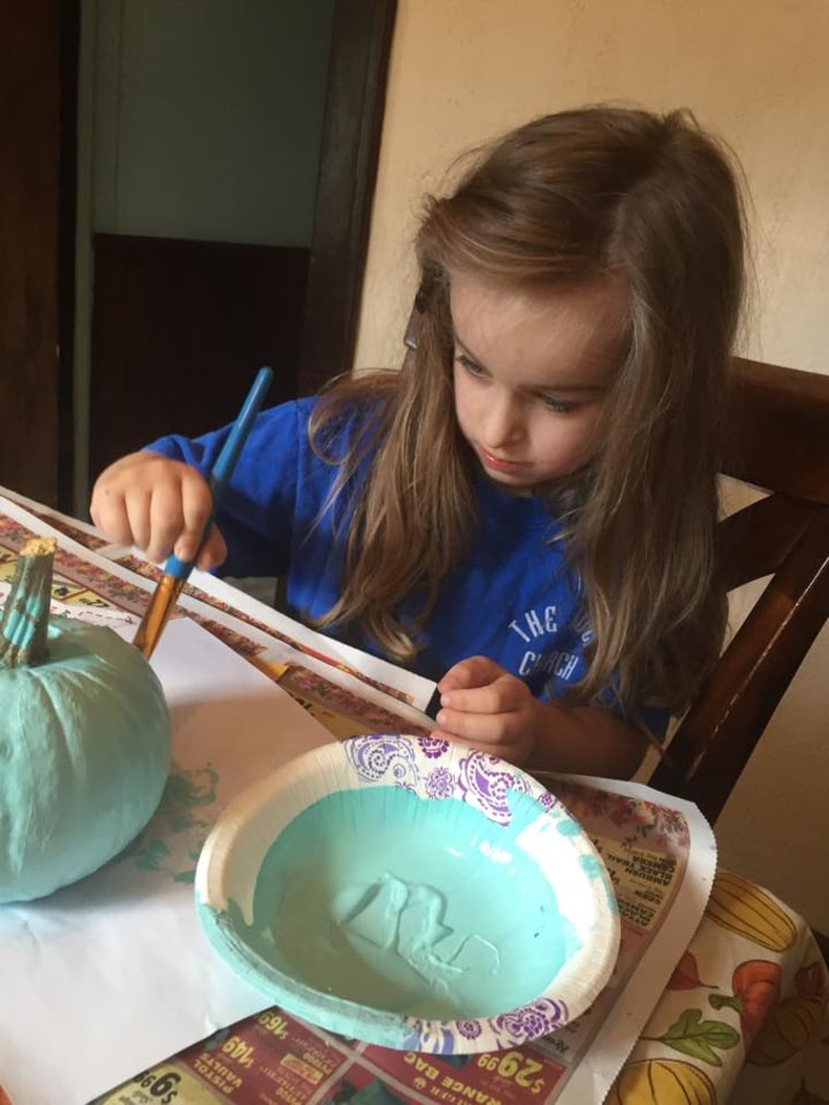 Abigail, 4, from Michigan, paints her pumpkin teal.