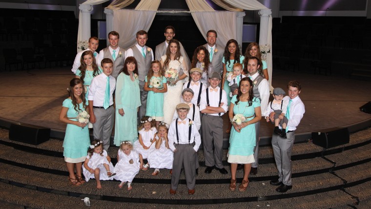 Jill and Derick on their wedding day with members of their families, including Jill's 18 siblings: Joshua, Jana, John-David, Jessa, Jinger, Joseph, Josiah, Joy-Anna, Jedidiah, Jeremiah, Jason, James, Justin, Jackson, Johannah, Jennifer, Jordyn-Grace and Josie.