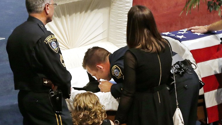 Oklahoma City police officer Sgt. Ryan Stark, center, leans over the casket of his canine partner, K-9 Kye, following funeral services for the dog in ...